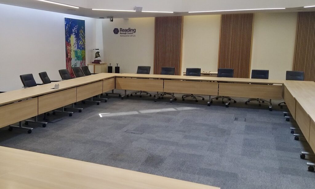 Empty council chamber with long tables